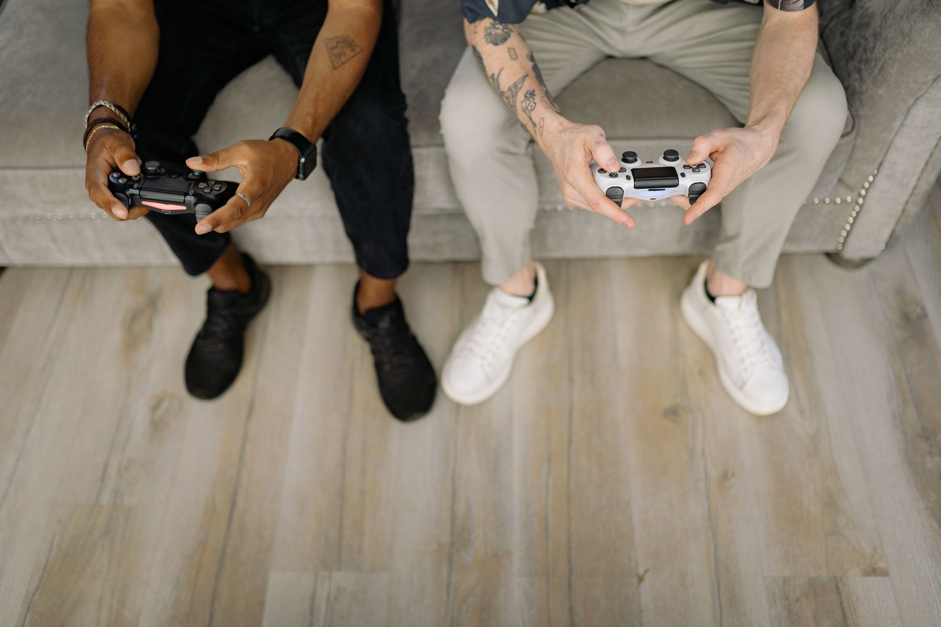 Two friends with gaming controllers focusing on a video game indoors from above. — Strategie wygrywania na klasycznym automac