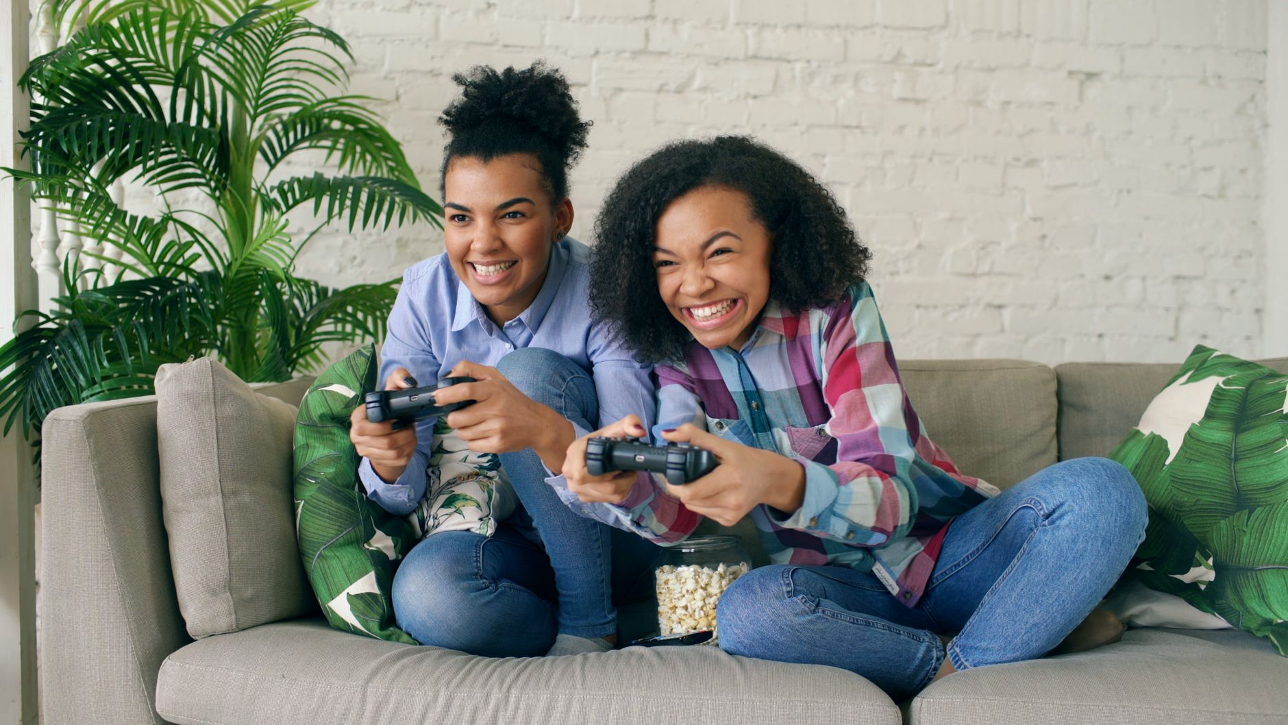 Two teenagers enjoying video games on a couch, showing excitement and joy. — Strategie wygrywania na klasycznym automacie Boo